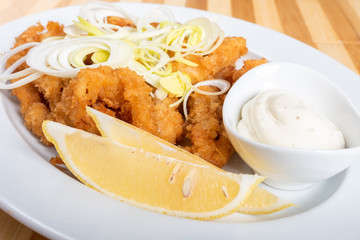 Grilled squid rings, with lemon and sauce.