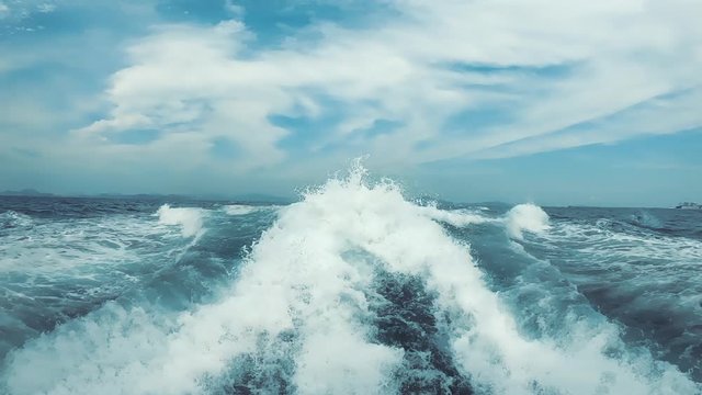 Very large waves with foam leave a cruise ship. Track from the ship on the water in the sea.