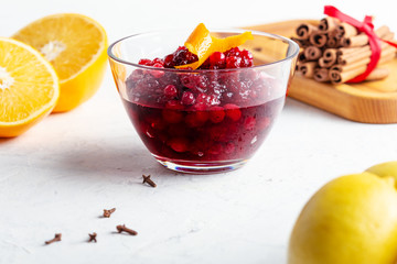 Thanksgiving cranberry sauce in glass bowl with fresh orange and lemon