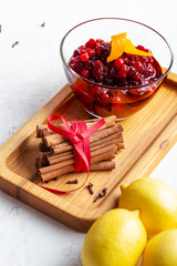 Thanksgiving cranberry sauce in glass bowl with fresh orange and lemon