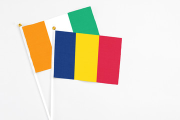Chad and Cote D'Ivoire stick flags on white background. High quality fabric, miniature national flag. Peaceful global concept.White floor for copy space.