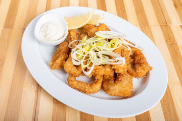 Grilled squid rings, with lemon and sauce.