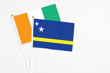 Curacao and Cote D'Ivoire stick flags on white background. High quality fabric, miniature national flag. Peaceful global concept.White floor for copy space.