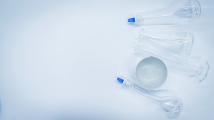 Volumetric flask,erlenmeyer flask, ceramic dish and Cylindermywhich is a scientific machine Used in the lab Is horizontally placed on a white background