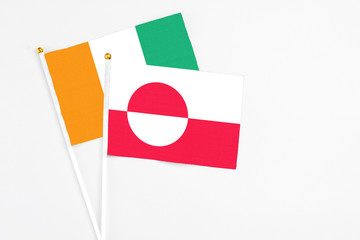 Greenland and Cote D'Ivoire stick flags on white background. High quality fabric, miniature...