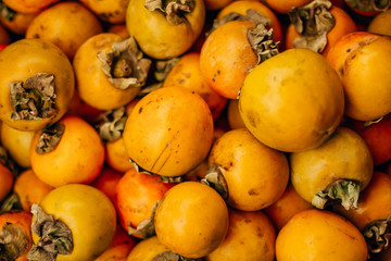 Naklejka na ściany i meble ripe tasty orange persimmon on the food market