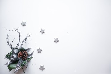 Christmas frame made of silver stars, snowflakes, cones, leaves and branches on white background. Winter concept. Flat lay, top view, copy space.Christmas composition.