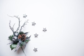 Christmas frame made of silver stars, snowflakes, cones, leaves and branches on white background. Winter concept. Flat lay, top view, copy space.Christmas composition.