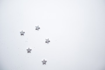 Christmas frame made Silver stars on white background. Winter concept. Flat lay, top view, copy space.Christmas composition.