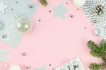 Fototapeta na wymiar Christmas frame. Pink flat lay styled scene - top view composition with silver christmas decorations. Pink background wth copy space
