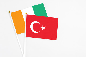 Turkey and Cote D'Ivoire stick flags on white background. High quality fabric, miniature national flag. Peaceful global concept.White floor for copy space.