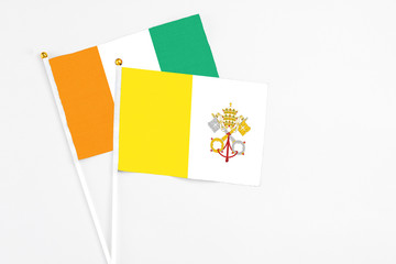 Vatican City and Cote D'Ivoire stick flags on white background. High quality fabric, miniature...