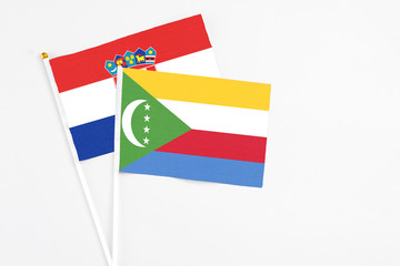 Comoros and Croatia stick flags on white background. High quality fabric, miniature national flag. Peaceful global concept.White floor for copy space.