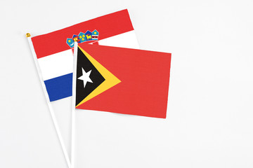 East Timor and Croatia stick flags on white background. High quality fabric, miniature national flag. Peaceful global concept.White floor for copy space.
