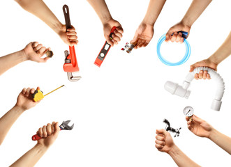 Hands with different plumber tools on white background