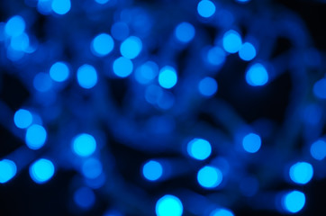 Fototapeta na wymiar Abstract pattern of blue bokeh garland lights on a dark background