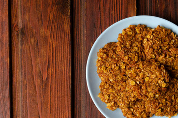 Pumpkin vegan oatmeal cookies with nuts on wooden background