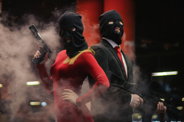 a classic in black costume with crimson galstucom and a girl in costume in a mask with weapons...