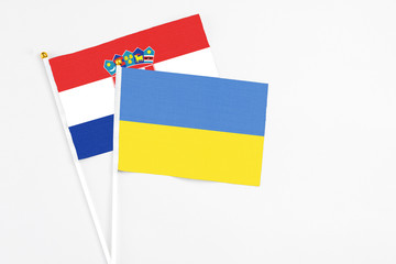 Ukraine and Croatia stick flags on white background. High quality fabric, miniature national flag. Peaceful global concept.White floor for copy space.