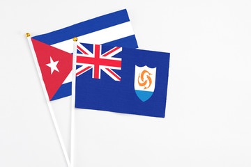 Fototapeta premium Anguilla and Cuba stick flags on white background. High quality fabric, miniature national flag. Peaceful global concept.White floor for copy space.