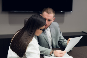 Two young business people discussing work during a business presentation in conference room
