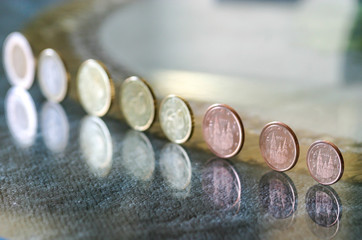 Euro coins on a glass table.