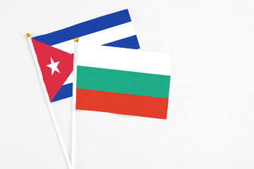 Bulgaria and Cuba stick flags on white background. High quality fabric, miniature national flag. Peaceful global concept.White floor for copy space.