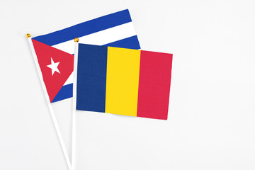 Chad and Cuba stick flags on white background. High quality fabric, miniature national flag. Peaceful global concept.White floor for copy space.