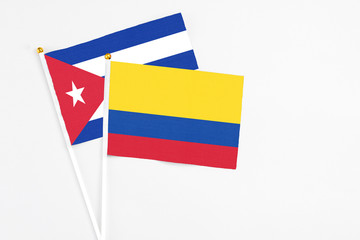 Colombia and Cuba stick flags on white background. High quality fabric, miniature national flag. Peaceful global concept.White floor for copy space.
