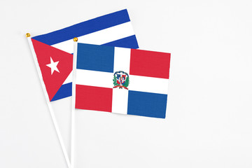 Dominican Republic and Cuba stick flags on white background. High quality fabric, miniature national flag. Peaceful global concept.White floor for copy space.
