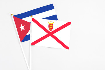 Jersey and Cuba stick flags on white background. High quality fabric, miniature national flag. Peaceful global concept.White floor for copy space.