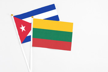 Lithuania and Cuba stick flags on white background. High quality fabric, miniature national flag. Peaceful global concept.White floor for copy space.