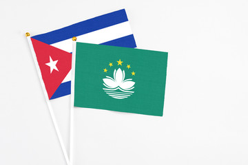 Macao and Cuba stick flags on white background. High quality fabric, miniature national flag. Peaceful global concept.White floor for copy space.