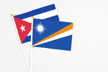 Marshall Islands and Cuba stick flags on white background. High quality fabric, miniature national...