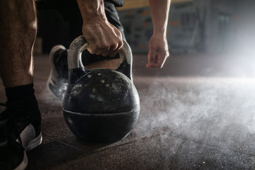 Sports background. Young athlete getting ready for crossfit training. Powerlifter hand in talc...