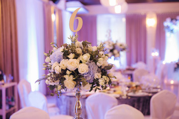 Wedding bouquet in restaurant on the table. Blue and white flowers. Rose and hydrangea