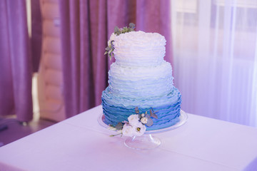 Beautiful wedding cake decorated with flowers. Blue and white color of cake