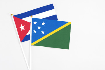 Solomon Islands and Cuba stick flags on white background. High quality fabric, miniature national...