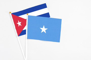 Somalia and Cuba stick flags on white background. High quality fabric, miniature national flag. Peaceful global concept.White floor for copy space.