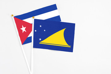 Tokelau and Cuba stick flags on white background. High quality fabric, miniature national flag. Peaceful global concept.White floor for copy space.