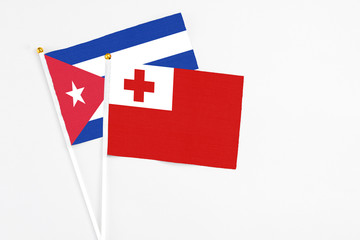 Tonga and Cuba stick flags on white background. High quality fabric, miniature national flag. Peaceful global concept.White floor for copy space.