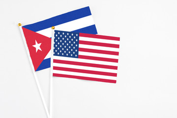 United States and Cuba stick flags on white background. High quality fabric, miniature national flag. Peaceful global concept.White floor for copy space.