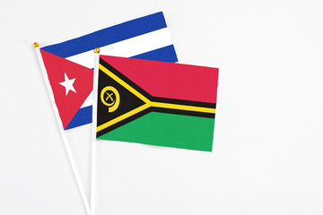 Vanuatu and Cuba stick flags on white background. High quality fabric, miniature national flag. Peaceful global concept.White floor for copy space.