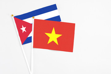 Vietnam and Cuba stick flags on white background. High quality fabric, miniature national flag. Peaceful global concept.White floor for copy space.