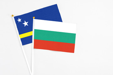 Bulgaria and Curacao stick flags on white background. High quality fabric, miniature national flag. Peaceful global concept.White floor for copy space.