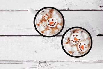  Twee kopjes vakantie warme chocolademelk met sneeuwpop marshmallows. Bovenaanzicht op een witte houten achtergrond. © Jenifoto