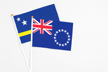 Cook Islands and Curacao stick flags on white background. High quality fabric, miniature national flag. Peaceful global concept.White floor for copy space.