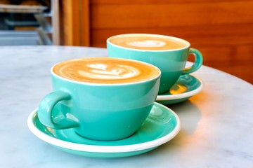 Two cups of coffee in mint green mugs.