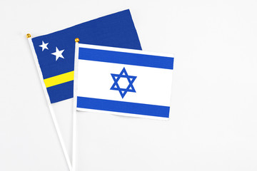 Israel and Curacao stick flags on white background. High quality fabric, miniature national flag. Peaceful global concept.White floor for copy space.