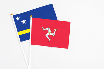 Isle Of Man and Curacao stick flags on white background. High quality fabric, miniature national flag. Peaceful global concept.White floor for copy space.